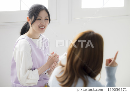 一位年輕的母親諮詢公共衛生護士 129056571