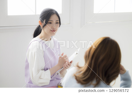 一位年輕的母親諮詢公共衛生護士 一位年輕的母親諮詢公共衛生護士 129056572