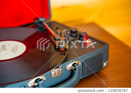 Close-up of record player needle tracking vinyl grooves during playback. Analog sound detail capturing retro music atmosphere. Close-up of record player needle tracking vinyl grooves during playback. Analog sound detail capturing retro music atmosphere. 129056767