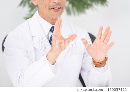 Medical image: Man in white coat, hand 129057111