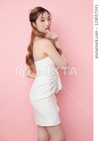 Beautiful face of young Asian woman in sexy dress white Perfect slim body on pink background, plastic surgery and aesthetic cosmetology, Facial and skin care concept 129057241