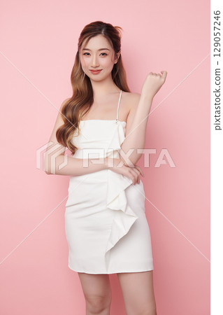 Beautiful face of young Asian woman in sexy dress white Perfect slim body on pink background, plastic surgery and aesthetic cosmetology, Facial and skin care concept 129057246