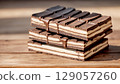 Stack of Premium Milk and Dark Chocolate Bars on Rustic Wooden Background 129057260
