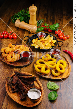 Delightful assortment of appetizers with sauces on a wooden table Delightful assortment of appetizers with sauces on a wooden table 129058112