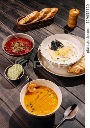 Delicious gourmet dishes served on a rustic wooden table Delicious gourmet dishes served on a rustic wooden table 129058120