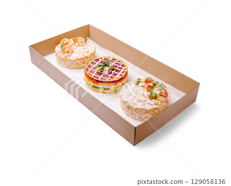 An elegant catering box featuring three beautifully styled layered salads shaped like cakes 129058136