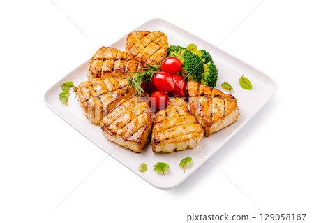 Grilled fish fillets served with cherry tomatoes and broccoli on a plate Grilled fish fillets served with cherry tomatoes and broccoli on a plate 129058167
