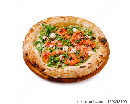 Delicious salmon pizza with arugula served on a wooden platter Delicious salmon pizza with arugula served on a wooden platter 129058193