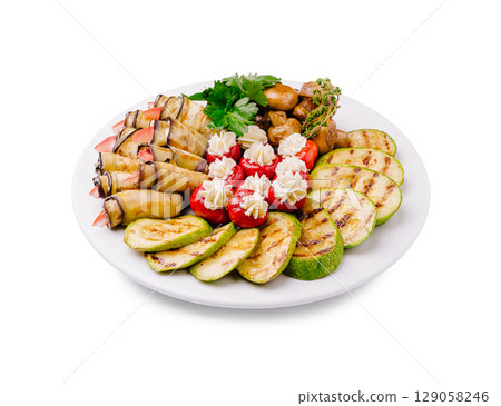 Colorful platter of grilled vegetables and seafood displayed on a white plate Colorful platter of grilled vegetables and seafood displayed on a white plate 129058246