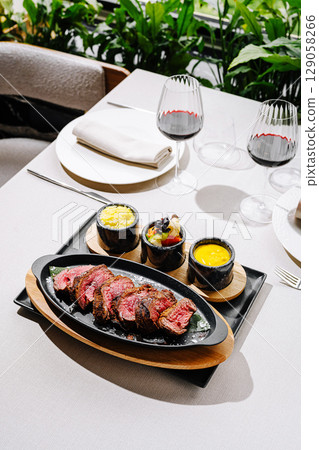 Delicious grilled steak served with sides in upscale dining setting Delicious grilled steak served with sides in upscale dining setting 129058266