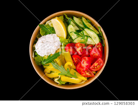 Colorful fresh salad bowl with creamy dressing on a dark background Colorful fresh salad bowl with creamy dressing on a dark background 129058303