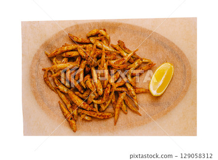 Delicious fried fish served on a platter with lemon wedge 129058312