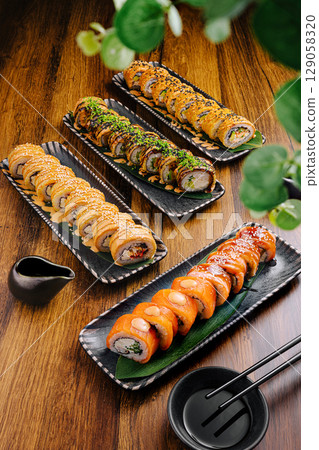 Sushi platter with assorted rolls presented on wooden table 129058320