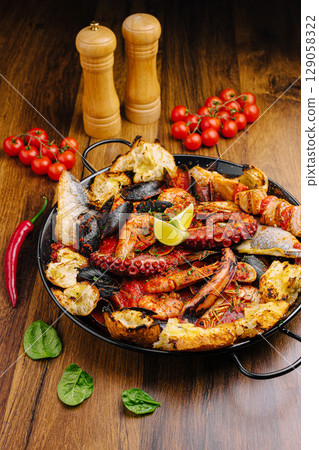 Fresh seafood feast featuring octopus, shrimp, and vegetables on wooden table 129058322