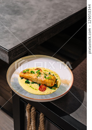 Delicious salmon dish served on a stylish plate at a modern dining table Delicious salmon dish served on a stylish plate at a modern dining table 129058344