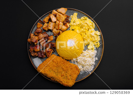 Assorted Romanian-style meal with creamy polenta, scrambled eggs, grilled meats and grated cheese 129058369