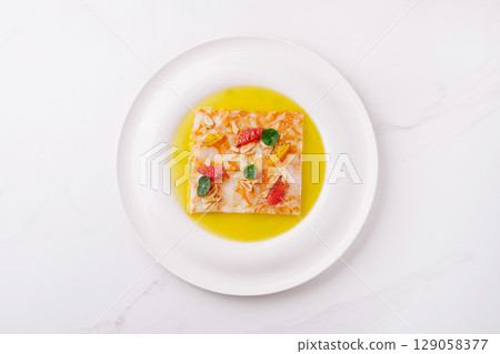 Colorful dessert with fresh fruits and a vibrant sauce on a white plate 129058377