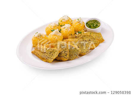 Savory platter features fried fish and spiced cheese balls with sauce Savory platter features fried fish and spiced cheese balls with sauce 129058398
