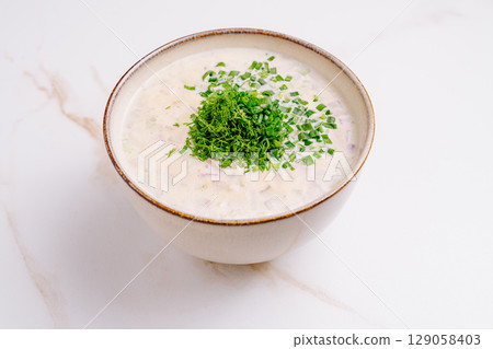 Delicious yogurt-based soup with fresh herbs served in a bowl Delicious yogurt-based soup with fresh herbs served in a bowl 129058403
