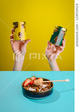 Healthy snacks displayed in colorful jars with fruit and honey on table Healthy snacks displayed in colorful jars with fruit and honey on table 129058429