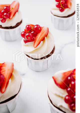 Fresh strawberry and red currant cupcakes in a vibrant setting 129058434