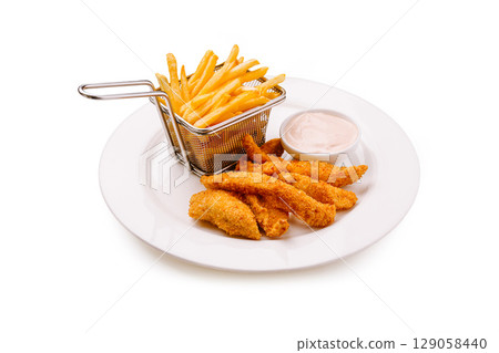 Crispy golden chicken tenders with fries and dipping sauce on white plate Crispy golden chicken tenders with fries and dipping sauce on white plate 129058440