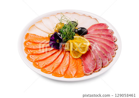 A beautifully arranged platter featuring thinly sliced salmon, pepper-crusted tuna, and white meat slices, garnished with lemon slices, black and green olives A beautifully arranged platter featuring thinly sliced salmon, pepper-crusted tuna, and white meat slices, garnished with lemon slices, black and green olives 129058461