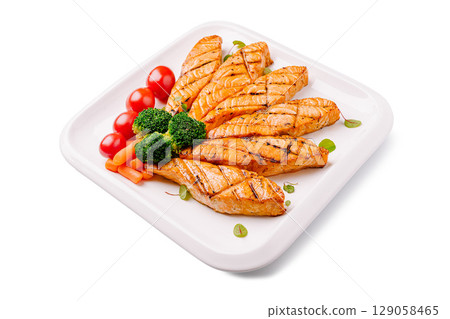 Grilled salmon fillets served with fresh vegetables and herbs 129058465