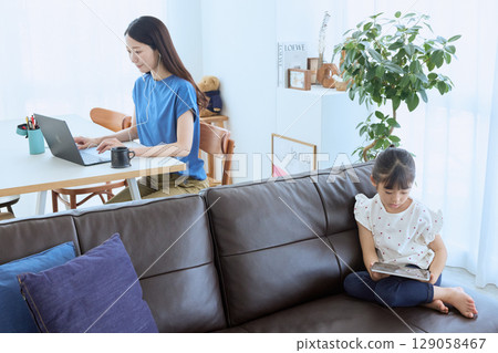 Mother working from home and child enjoying tablet 129058467