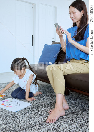 在孩子畫畫時在旁邊使用智慧型手機 129058525