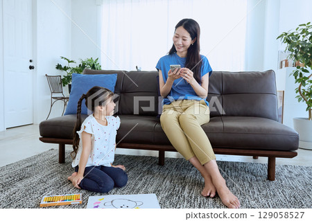 在孩子畫畫時在旁邊使用智慧型手機 在孩子畫畫時在旁邊使用智慧型手機 129058527