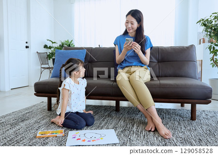 在孩子畫畫時在旁邊使用智慧型手機 在孩子畫畫時在旁邊使用智慧型手機 129058528