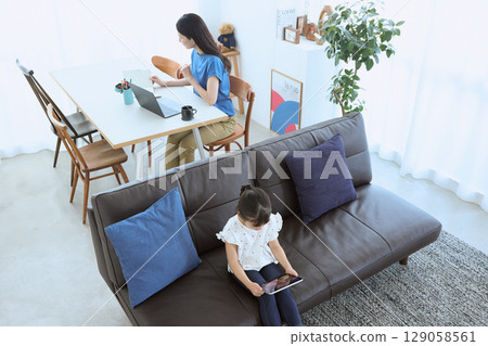 Mother working from home and child enjoying tablet 129058561