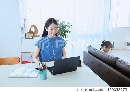 Mother working from home and child enjoying tablet 129058575