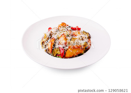 Delicious vegetable casserole with cheese served on a white plate 129058621