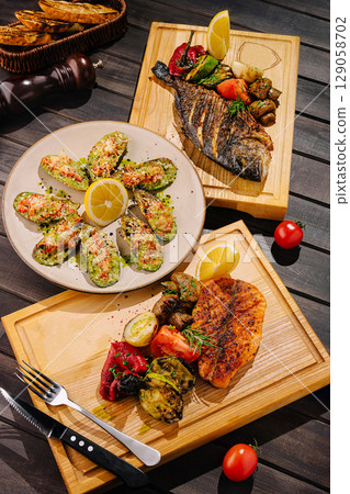 Grilled seafood and veggies on wooden platters at a restaurant Grilled seafood and veggies on wooden platters at a restaurant 129058702