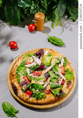 Fresh salad pizza topped with chicken, vegetables, and herbs 129058724