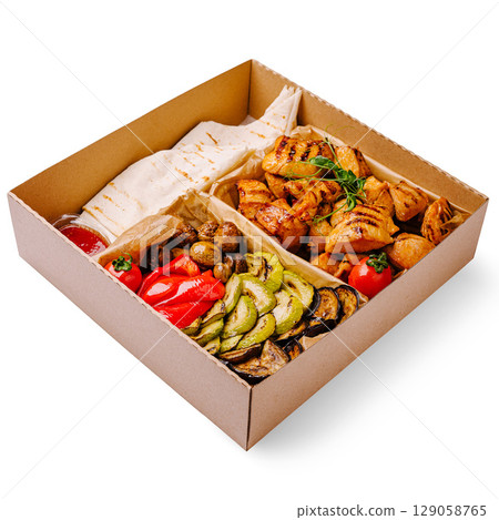 Delicious grilled chicken and vegetable platter served in a takeout box 129058765