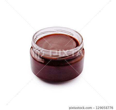 Chocolate sauce in a glass jar on a white background for dessert Chocolate sauce in a glass jar on a white background for dessert 129058776