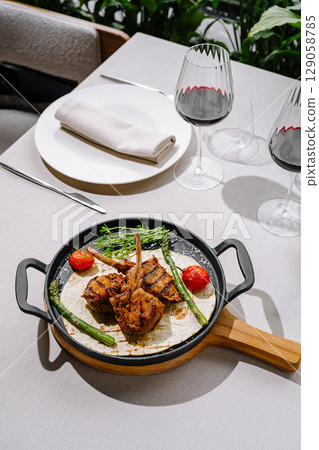 Delicious grilled lamb chops served with vegetables at a restaurant Delicious grilled lamb chops served with vegetables at a restaurant 129058785