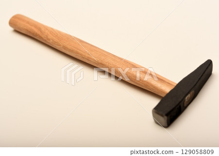 A small hammer with a wooden handle. A hammer on a white background. 129058809