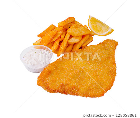 Crispy fried schnitzel with golden fries and tartar sauce served with lemon 129058861