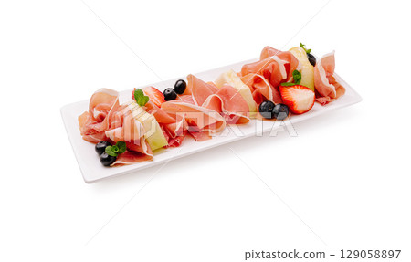 Delicious charcuterie platter featuring prosciutto with berries and mint Delicious charcuterie platter featuring prosciutto with berries and mint 129058897