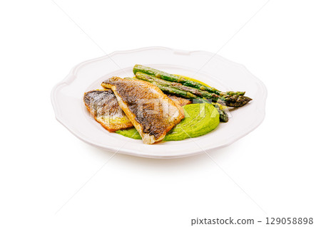 Delicious pan-seared fish with asparagus and green puree served on a plate 129058898