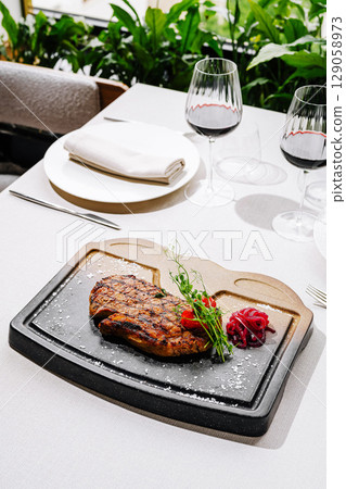 Delicious grilled steak served on hot stone with sides in elegant restaurant 129058973