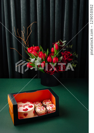 Celebration cake and cupcakes with flowers arranged for special occasion 129058982