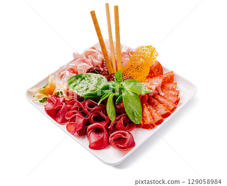 Charcuterie platter featuring assorted meats and garnishes for a gathering 129058984