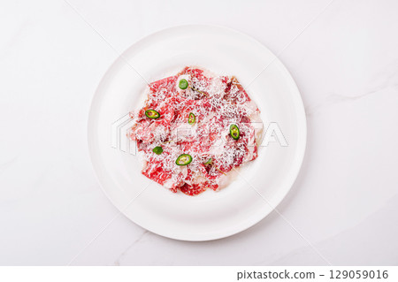 Spicy Beef Carpaccio with Parmesan and Green Chili on white plate 129059016