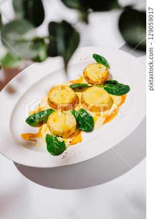 Gourmet Vegetable Medallions with Creamy Sauce and Spinach Leaves Gourmet Vegetable Medallions with Creamy Sauce and Spinach Leaves 129059017