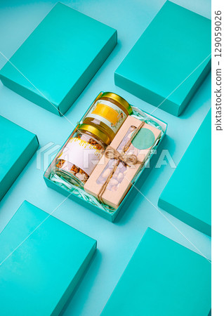 Unique gift box arrangement featuring colorful jars and wooden utensils 129059026